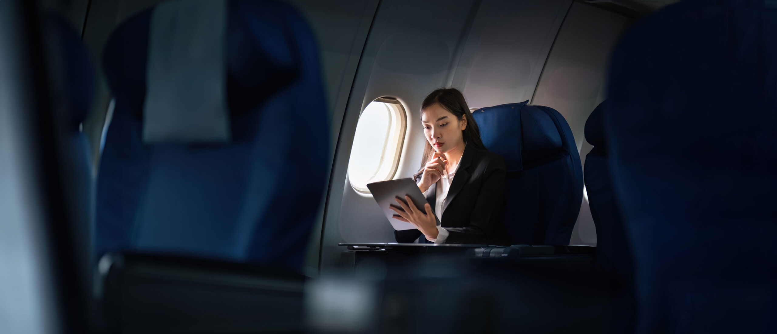 Female business traveller checking a tablet on flight