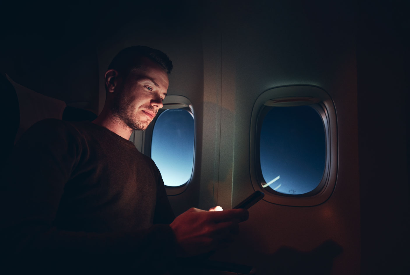 Man reading reading online news on a flight