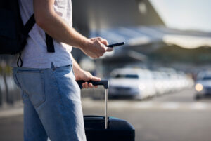 Man using phone at airport to call a taxo